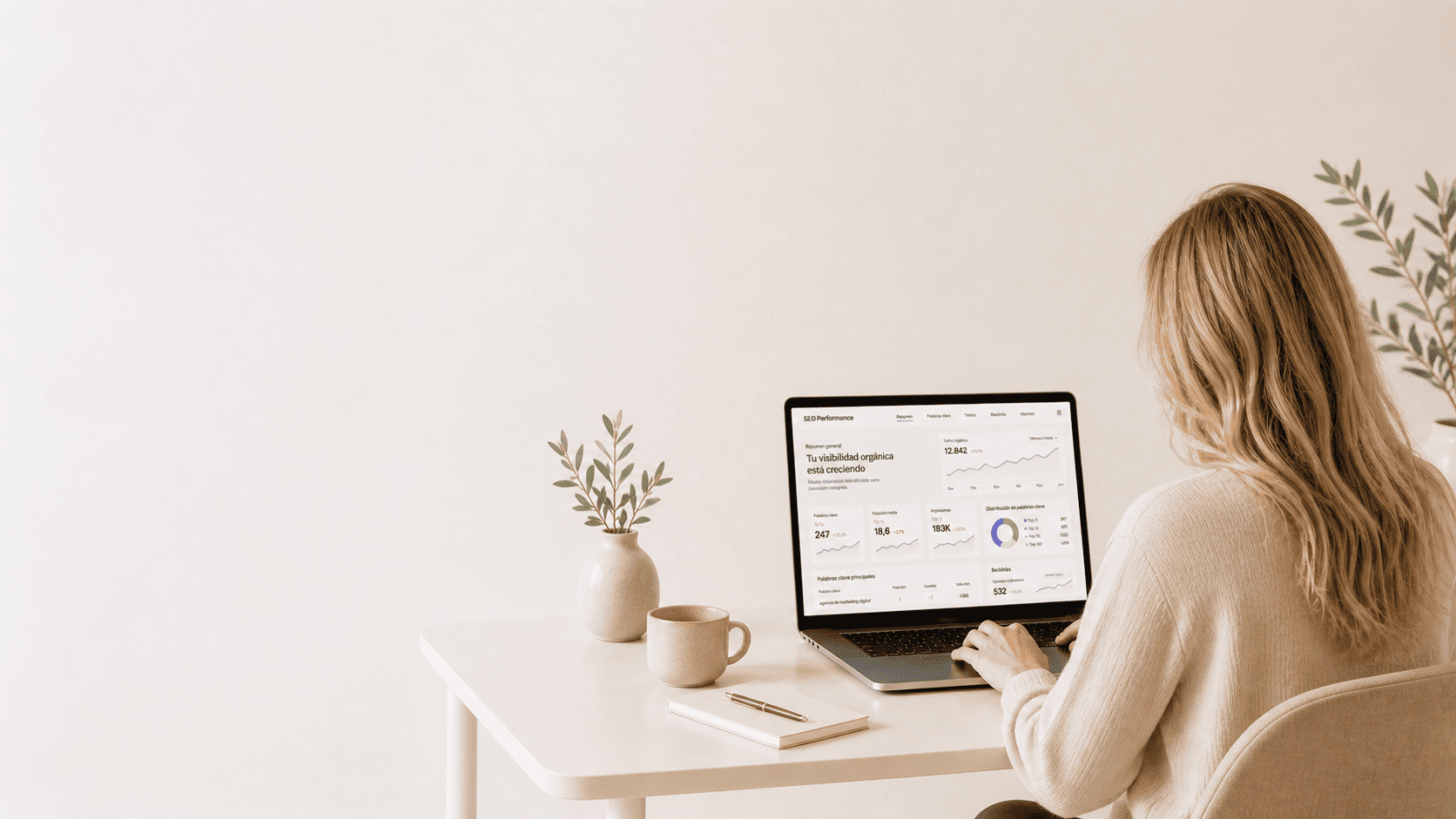 Mujer revisando métricas SEO y posicionamiento web desde un portátil